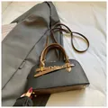 Detail view of contrast color handbag with gold hardware and protective base studs - No Pendant / Black