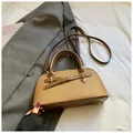 Detail of minimalist two-tone square handbag showing adjustable strap and metal bag feet - No Pendant / Brown