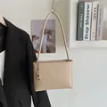 Minimalist beige soft leather bucket bag with silver chain charm and long shoulder strap - Khaki With Rabbit Pendant