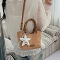 Brown bucket shoulder bag with star charm shown in a minimalist home setting - Brown With Pendant