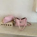 Pink lychee texture crossbody bag set with pearl charm on a minimalist stone surface - Pink
