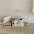Minimalist cream white crossbody bag set with pebble leather texture and fur ball charm - White
