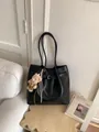 Black leather tote bag with long shoulder straps and a cute brown plush bear charm - With Charm / Black