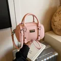 Roze mini Boston tas van imitatieleer met lycheestructuur, ronde handvatten en riem - Roze (Zonder Hanger)