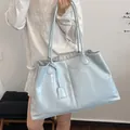 Light blue glossy leather large tote bag with long handles and decorative leather charm - Blue
