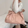 Minimalist soft pink tote bag in glossy leather shown as a large capacity shoulder bag - Pink