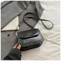 Elegant black pleated leather crossbody bag with adjustable strap on white linen - No Pendant / Black