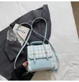 Mini mochila de cuadros azul claro con correas ajustables sobre fondo de blazer gris - Azul Sin Colgante