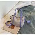 Minimalist canvas handbag with lilac straps and crossbody strap on white bedding - Small Purple