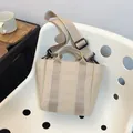Minimalist beige canvas bucket bag with wide adjustable shoulder strap and reinforced handles - Khaki