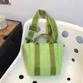 Light green canvas bucket bag with contrast dark green straps in minimalist style - Green