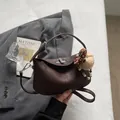 Dark brown matte leather dumpling bag with silver lock and plush bear charm - Coffee with Pendant