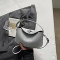Minimalistische mattgraue Lederhandtasche in Halbmondform mit Metalldrehverschluss - Blau