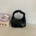 Detailed view of black wrinkled leather crescent bag with stylish ruched handle design - Black