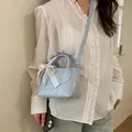Borsa a tracolla azzurra con fiocco di perle e manici in un ambiente morbido - Blu