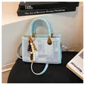 Bolso cuadrado azul claro texturizado con asas trenzadas y colgante de cuentas retro - Azul