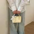 Secchiello in pelle giallo chiaro con fiocco in seta bianca e ciondoli di perle - Giallo