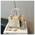 Bolso cuadrado beige texturizado con asas trenzadas y colgante de cuentas de madera - Blanco