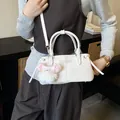 White faux leather bucket bag with plush bear charm and adjustable shoulder strap - White