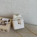 Detail der Herzsteppung und Schleife an einer weißen Mini-Kettentasche - Weiß
