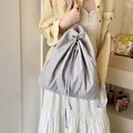 Light grey drawstring backpack in soft fabric shown with casual everyday outfit - Gray