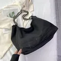 Detailansicht der schwarzen Denim-Tasche mit Silberkette und lässigem Design-Detail - Schwarz