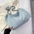 Detail der hellblauen Denim Hobo-Tasche mit Metallkette und gerafften Stoffdetails - Hellblau