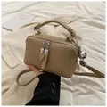 Detail view of khaki PU leather handbag with dual zipper closure and silver ball charm - Khaki