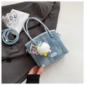 Sac à main bleu clair en denim avec pendentif cœur et bandoulière sur une veste grise - Bleu Clair (Avec Pendentif)