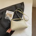 Detailansicht der gewebten Hobo-Tasche auf einem Blazer mit stilvollen Accessoires für den Alltag - Gelb