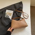 Detail der braunen geflochtenen Ledertasche mit silbernen Beschlägen und Gurt - Khaki