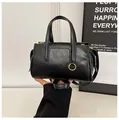Chic black faux leather handbag with golden metal rings and adjustable shoulder strap - Black without Charm