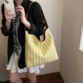 Bolso tote de punto a rayas amarillas y blancas con correa de piel sintética marrón - Amarillo