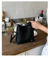 Sac seau en cuir grainé noir avec logo argenté et large bandoulière pour le quotidien - Noir