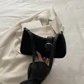 Schwarze Baguette-Schultertasche mit Silberschnalle auf beigem Blazer-Hintergrund - Schwarz