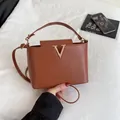 Chic brown leather bucket bag with gold V logo and adjustable shoulder strap - Brown