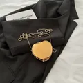Mini sac pomme doré brillant avec bandoulière en perles métalliques sur blazer noir - Or Pomme