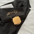 Mini sac chaîne en métal doré poli pour écouteurs avec finition brillante sur un costume - Carré Acrylique Or