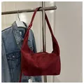 Macro detail of wine red suede hobo bag texture and elegant crescent moon design - Red