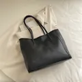 Minimalist black leather tote bag with slim shoulder straps for a classic retro commute look - Black