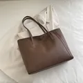 Minimalist deep brown faux leather tote bag with elegant long handles for daily commute - Brown