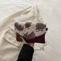 Modieuze enveloppe kettingtas met roodbruine koeprint flap en metalen schouderriem - Rood