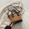 Brown suede bucket bag with quilted stitching, black trim and gold rivet details - Brown