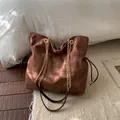 Dark brown suede bucket bag featuring golden chain strap and adjustable drawstring details - No Pendant / Brown
