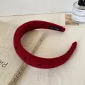 Red padded headband with black heart pattern and Hand Made label in lifestyle setting - Padded Headband / Black Heart Red