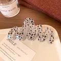 Glittery grey-purple wave hair claw clip featuring black heart patterns on a ceramic tray - Wave Black Heart