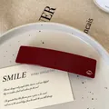 Elegant deep red acetate hair clip with a gold square logo detail for women - Red