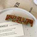 Rectangular acetate hair clip featuring blue and brown marble texture with gold logo accent - Green & Brown