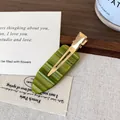 Olive green acetate teardrop hair clip with wavy texture and golden metal duckbill base - Green Stripe