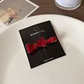 Pince à cheveux nœud rouge translucide en acrylique avec clip doré sur carte noire - Rouge Foncé